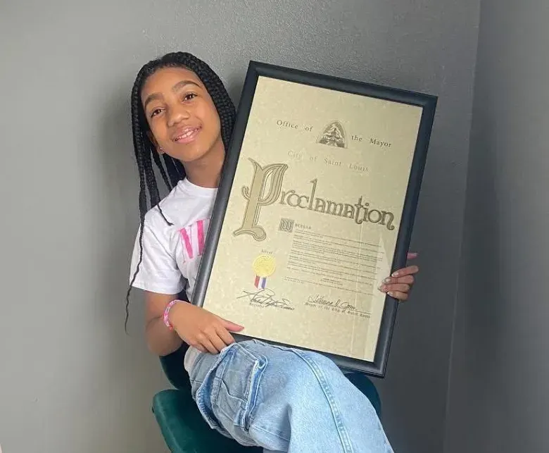 Paris holding the framed proclamation from the City of St. Louis